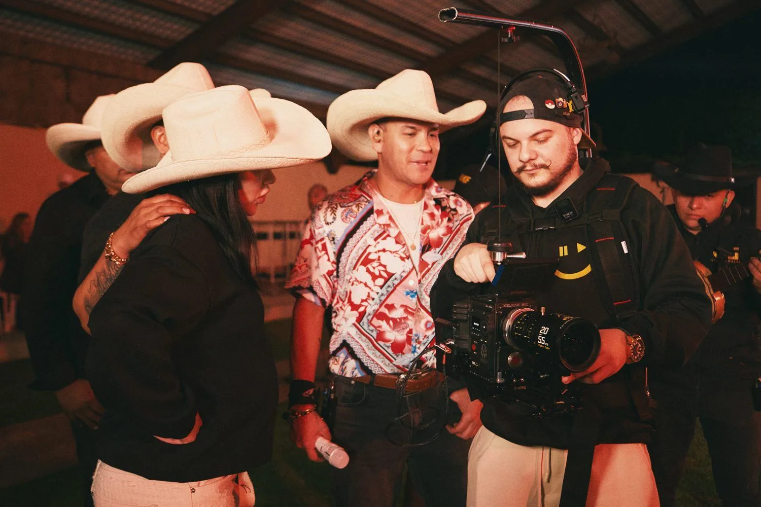 Serson filmando a artistas con sombreros vaqueros en un evento
